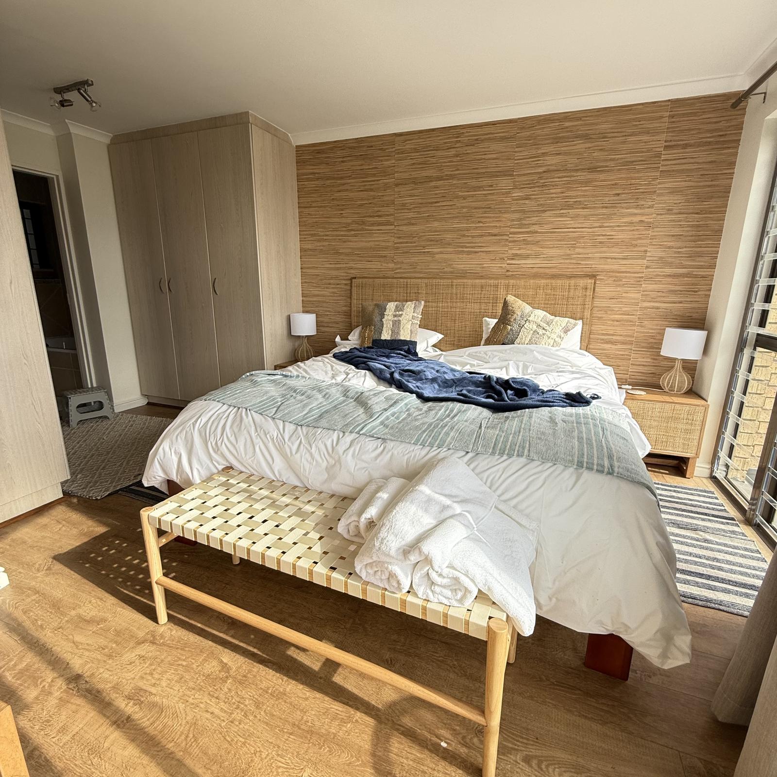 Peak-a-Blue king bedroom with natural wood wall