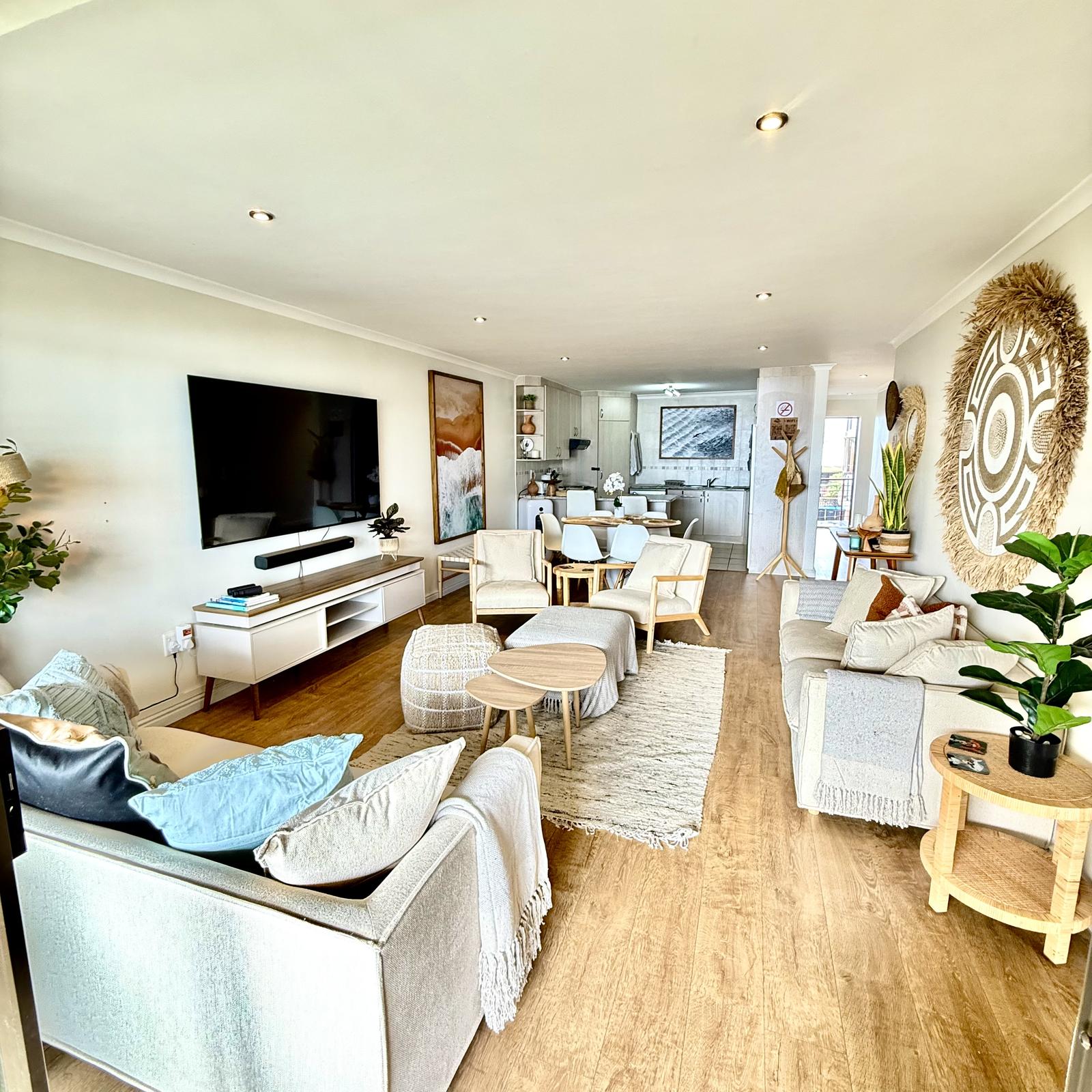 Peak-a-Blue open plan living area with TV and ocean art